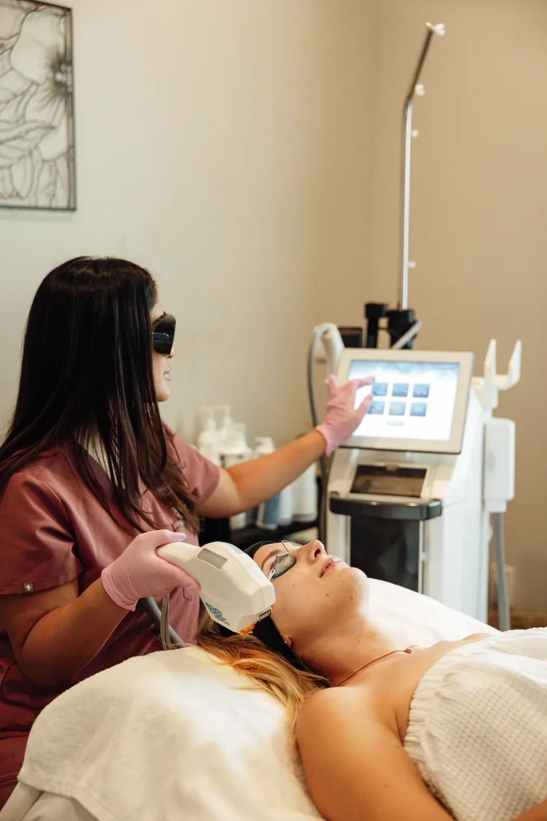 Esthetician performing a BBL HEROic photofacial on a relaxed client in the treatment room